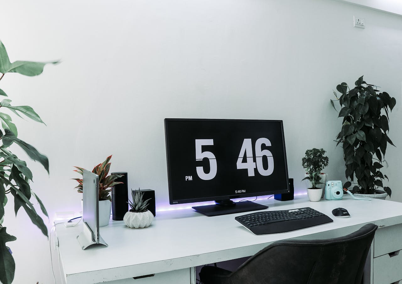 hero-about A sleek, contemporary desk setup featuring a monitor, plants, and minimalist decor for remote work.